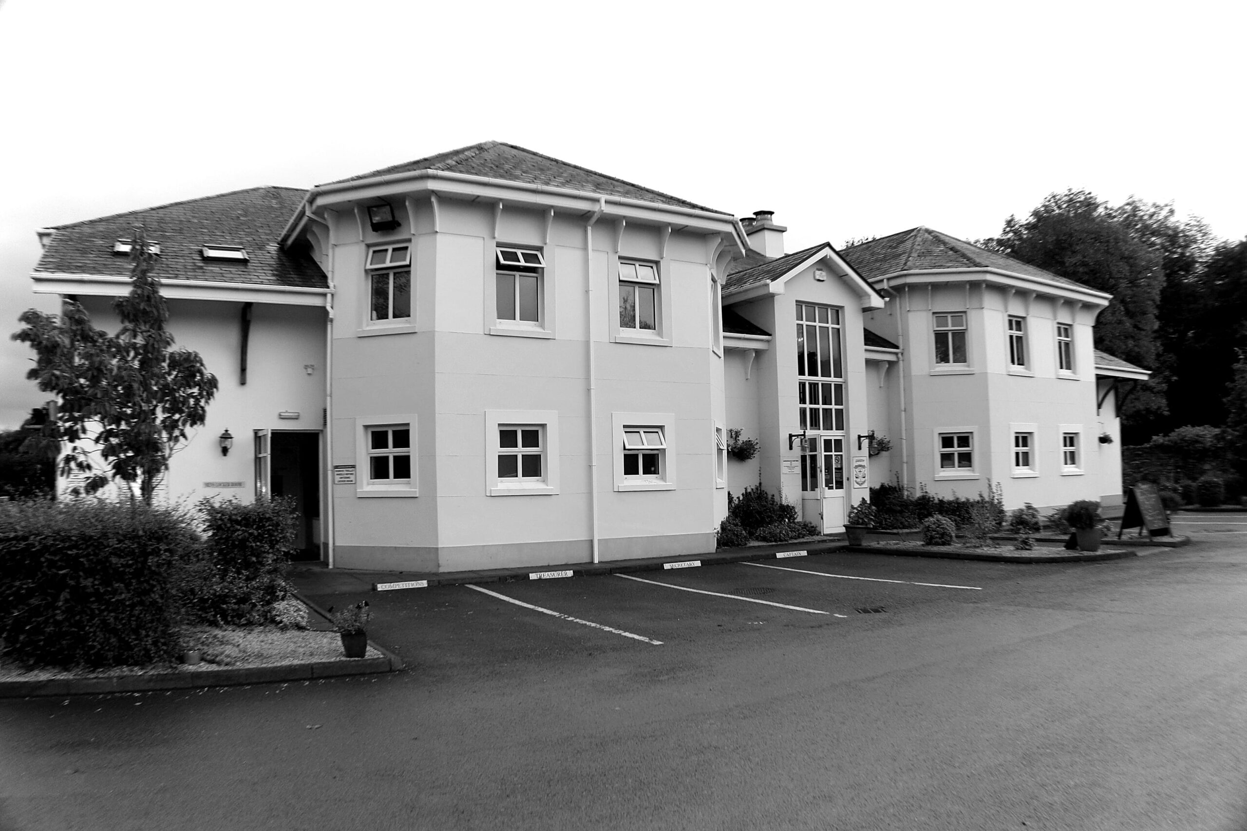 Barnhill John Hunter Esq Sm | Bogstown.com Two-story light building with many windows and a central glass entrance, in a paved parking lot.